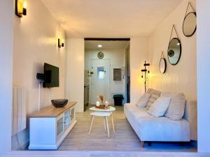 a living room with a couch and a table at Le Cosy du Lagon bleu in Fréjus