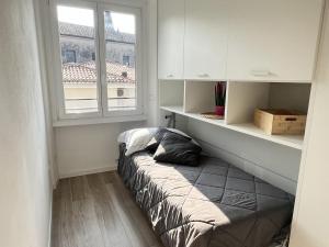 a bed in a room with a window at Sottovento Beths House in Brenzone sul Garda