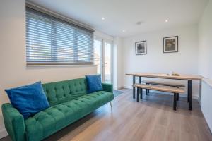 a green couch in a living room with a table at 38 Prospect Place, Leiston in Leiston