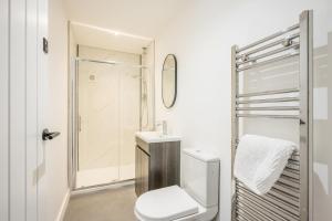a white bathroom with a toilet and a shower at 38 Prospect Place, Leiston in Leiston +23 photos
