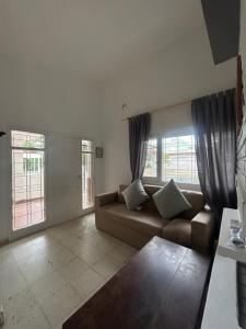 a living room with a couch and two windows at Casa Kempes in Córdoba