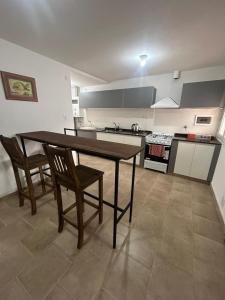 a kitchen with a wooden table and two chairs at Casa Kempes in Córdoba