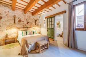 a bedroom with a bed and a stone wall at Calma Hotel in Ciutadella