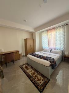a bedroom with a large bed and a piano at Aga Stay Apartment in Gangtok
