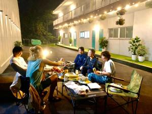 a group of people sitting at a table with food at FujiteraCanvas102 in Gotemba