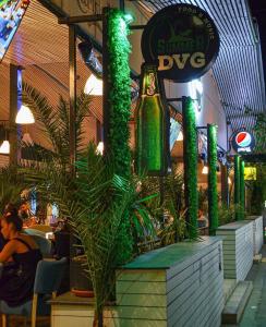 a restaurant with green plants and a beer bottle at VILA DVG II in Costinesti