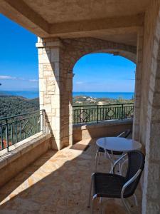 a balcony with a table and chairs and a view at AGAPI Holiday House in Vouníon