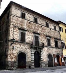 a large brick building with windows and a balcony at Palazzo Bruschi in Pergola