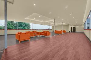 an empty lobby with orange furniture and windows at Hotel O Ciapus Bogor in Bogor