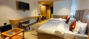 a hotel room with a bed and a television at Shail Shikhar Heritage Inn in Joshīmath