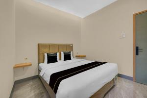 a bedroom with a large white bed with two pillows at Hotel O Ciapus Bogor in Bogor