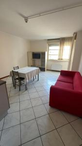 a living room with a red couch and a table at Savi Residence in Savigliano