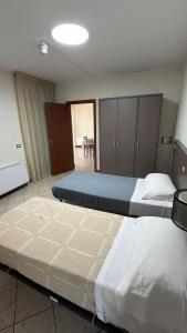 a bedroom with two beds and a dining room at Savi Residence in Savigliano