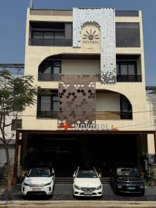 two cars parked in front of a building at Novosol Lux- A Premium Hotel Near Airport in Jaipur