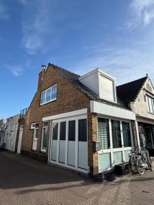a brick house with white doors on a street at Homes by the C in Zandvoort