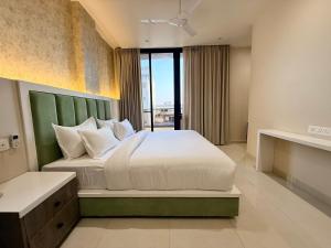 a bedroom with a large bed with a large window at Novosol Lux- A Premium Hotel Near Airport in Jaipur +22 photos