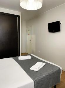 a bedroom with a bed with two towels on it at Vila Hotel By VimaHotels in Guimarães