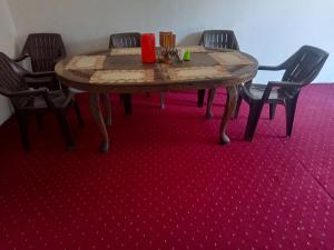 a table in a room with chairs and a red carpet at Inayat hotel in Srinagar