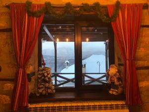 a window with red curtains and a teddy bear at Paradise - Guest House in Beden +8 photos