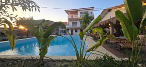 a resort with a swimming pool in front of a building at Calamianes Homestay in Coron