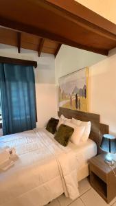 a bedroom with a large white bed with a painting on the wall at Hotel Hassler in Asunción +51 photos