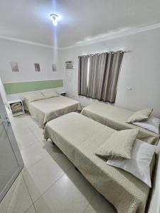 a hotel room with two beds and a window at Novo Maanaim Hotel in Presidente Epitácio +74 photos