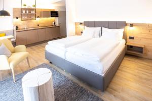 a bedroom with a large bed and a kitchen at keyone homes Hochficht in Ulrichsberg