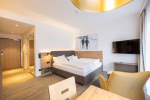 a bedroom with a bed and a tv and a table at keyone homes Hochficht in Ulrichsberg