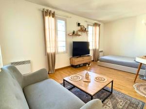 a living room with a couch and a tv at Studio cosy avec Smart TV & Wi-Fi in Le Plessis-Robinson