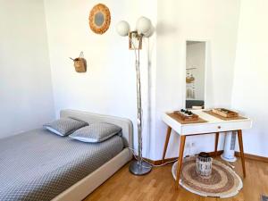 a bedroom with a bed with a table and a lamp at Studio cosy avec Smart TV & Wi-Fi in Le Plessis-Robinson