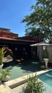 a patio with a pool and umbrellas next to a building at Hotel Hassler in Asunción