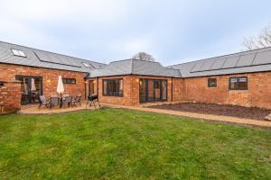 a brick house with a lawn in front of it at The Stables in Huntingdon