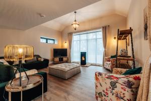a living room with a couch and a tv at The Stables in Huntingdon
