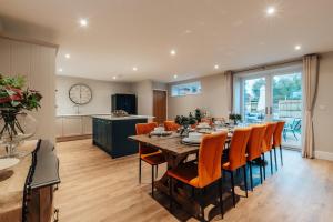 a dining room with a long table and orange chairs at The Stables in Huntingdon