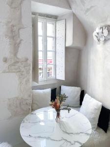 a white room with a table and a window at Le Cocon - 3 étoiles in Annecy