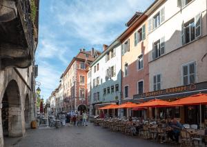 a city street with tables and chairs and buildings at Le Cocon - 3 étoiles in Annecy +16 photos
