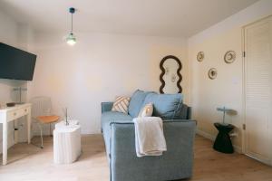 a living room with a blue couch and a table at Les archives de Georges 153 - Appart' de standing en centre-ville - Balcon privé, Climatisation, Caméra de vidéo surveillance in Périgueux