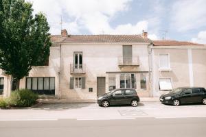 two cars parked in a parking lot in front of a building at Les archives de Georges 153 - Appart' de standing en centre-ville - Balcon privé, Climatisation, Caméra de vidéo surveillance in Périgueux