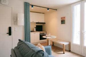 a living room with a couch and a table at Les archives de Georges 153 - Appart' de standing en centre-ville - Balcon privé, Climatisation, Caméra de vidéo surveillance in Périgueux +13 photos