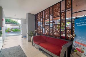 a waiting room with a red couch in a building at Palette Legian Beach in Legian