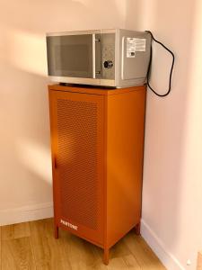 a microwave sitting on top of a wooden cabinet at Maisonnette en coeur de ville in Cosne-Cours-sur-Loire +8 photos