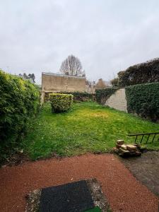 a grassy yard with a building in the background at Maisonnette en coeur de ville in Cosne-Cours-sur-Loire