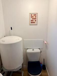 a white bathroom with a toilet and a blue stool at Maisonnette en coeur de ville in Cosne-Cours-sur-Loire