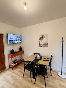 a dining room with a table and chairs and a tv at Maisonnette en coeur de ville in Cosne-Cours-sur-Loire