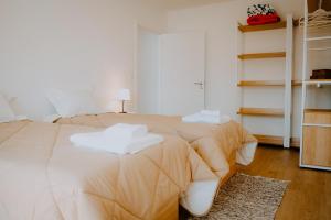a bedroom with two beds with towels on them at Slow Living Apúlia in Apúlia