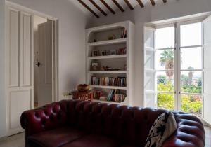 a leather couch in a living room with a book shelf at Finca Antas Villa in Antas