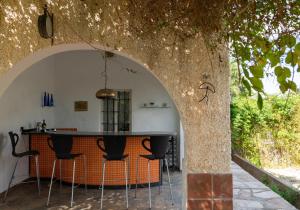 an archway in a kitchen with stools under a tree at Finca Antas Villa in Antas