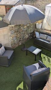 a patio with two chairs and an umbrella at Aux Cormulets in La Baconnière