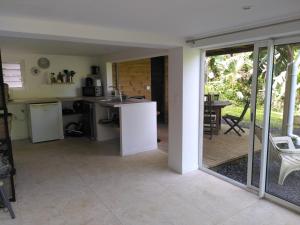 a kitchen and dining room with sliding glass doors at Studio dans la forêt tropicale in Les Anses-dʼArlets