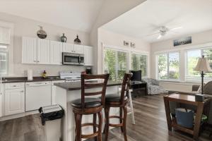 a kitchen with white cabinets and a table and chairs at The Bluebird - 34 Meadow View in Cherry Valley
